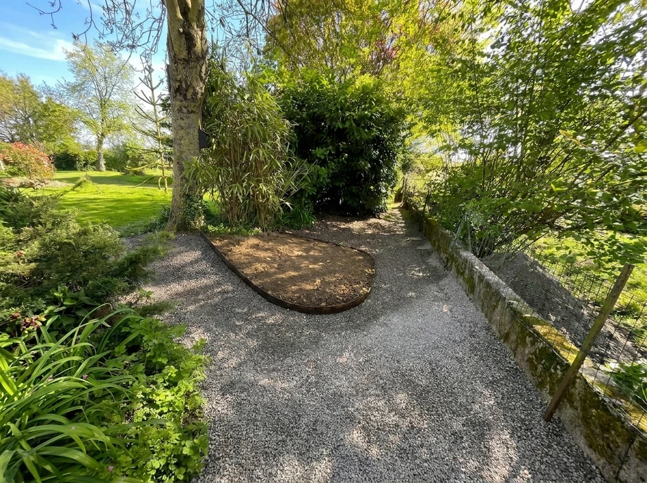 Scène extérieure de jardinage professionnel avec homme utilisant une tondeuse autoportée orange sur pelouse verte entretenue